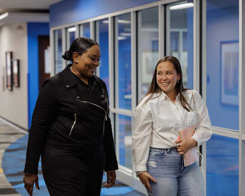 Professor Eve Lynn Clarke walking with a student
