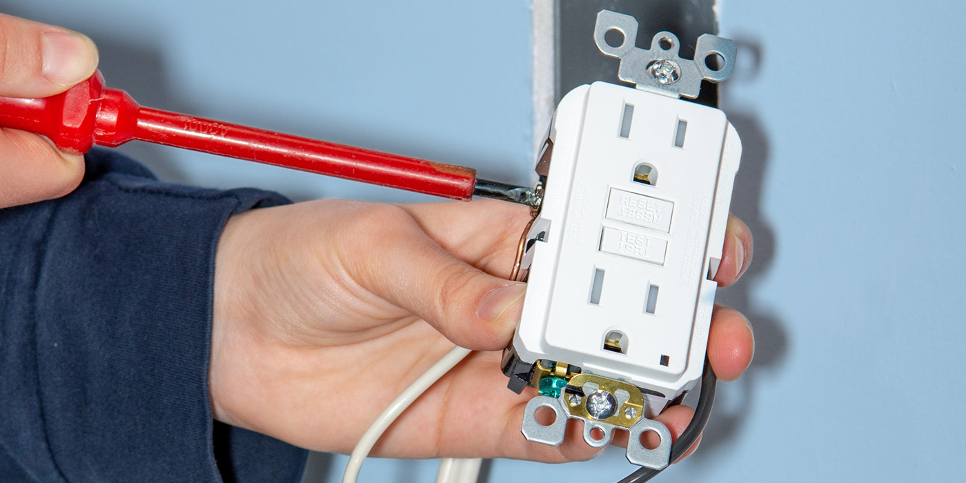 Residential electrician wiring an outlet