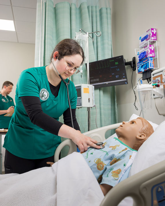 Nursing student Melanie Peters practicing on a dummy