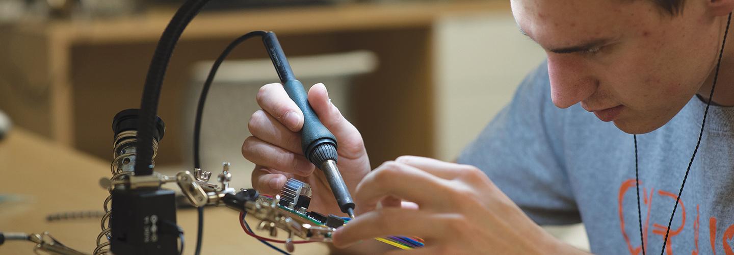 Student soldering a project in a computer engineering class