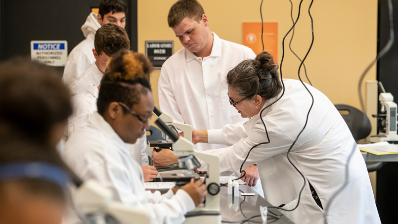 Professor Good assisting students in the bio lab